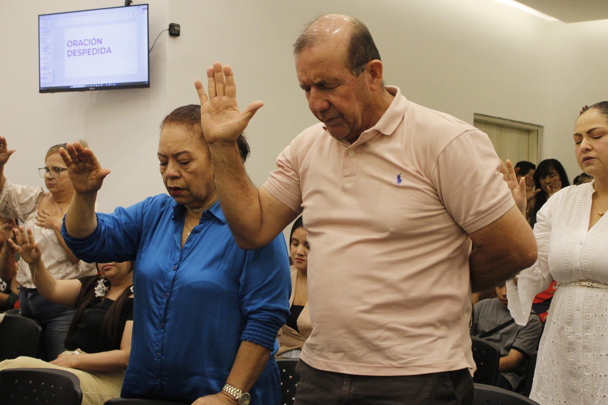 Personas de distintas edades orando juntas en un servicio de Visión de Reino